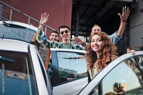 Company of four friends getting into the car