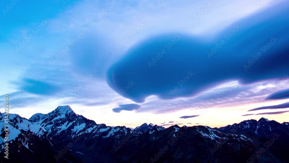 Time lapse of lenticular clouds paint in pink in motion at the sunset above the snowy summit of mount Cook the aoraki mount cook national park in the south island of New Zealand Time lapse of lenticular clouds paint in pink in motion at the sunset above the snowy summit of mount Cook the aoraki mount cook national park in the south island of New Zealand