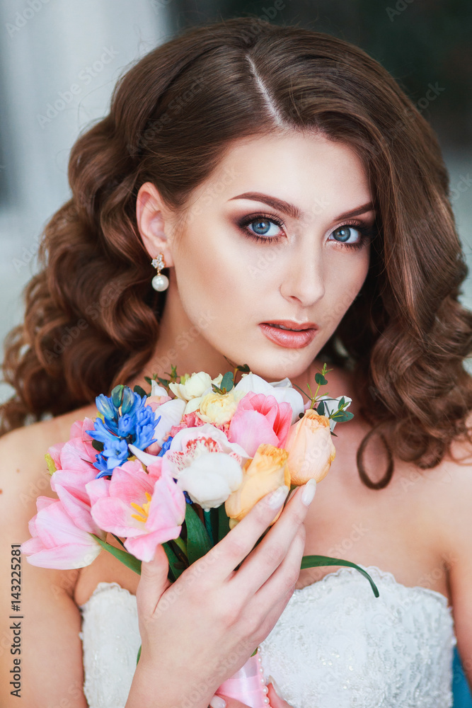 Beautiful young bride with wedding makeup and hairstyle indoor .Closeup portrait of young gorgeous bride in studio