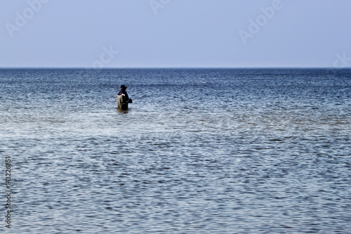 Lone fisherman fishing in the Baltic Sea.
