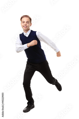 Teenage boy in school uniform running on white background