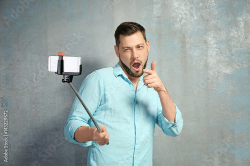 Young man taking selfie whi...
