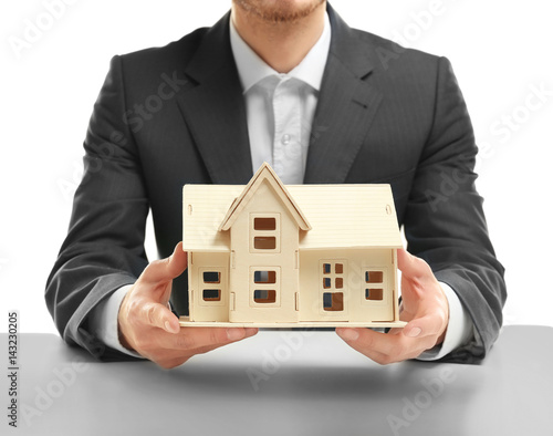Man holding house model on white background