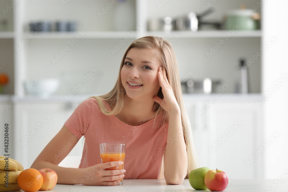 Young woman tasting fresh juice at kitchen Young woman tasting fresh juice at kitchen