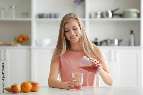 Young woman pouring fresh j...