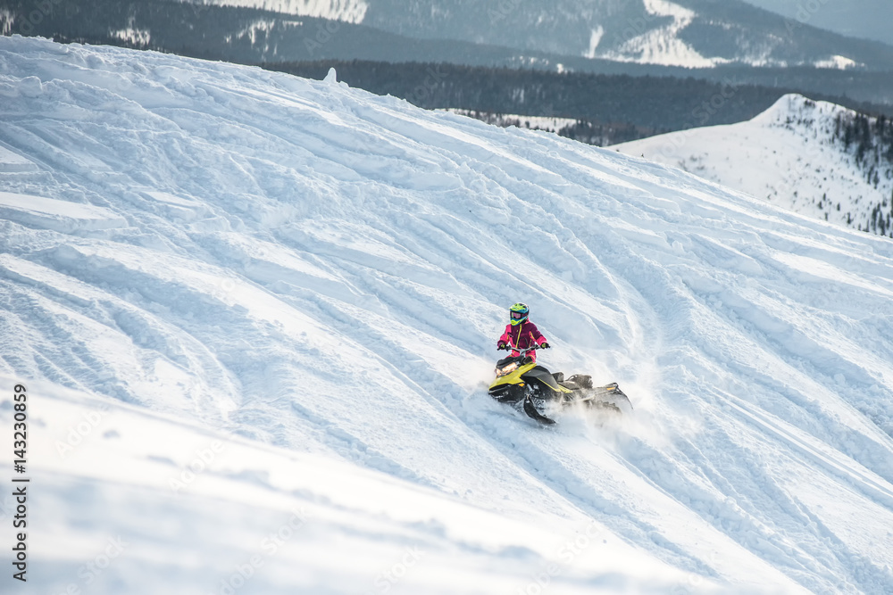 Rider on the snowmobile in the mountains . the movement of the traverse