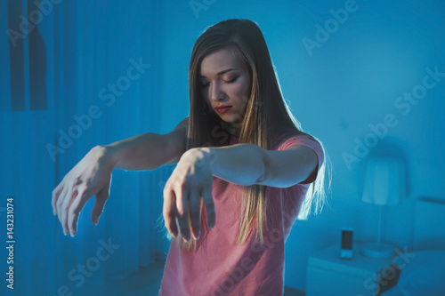 Fotografia Young sleepy woman suffering from somnambulism at home