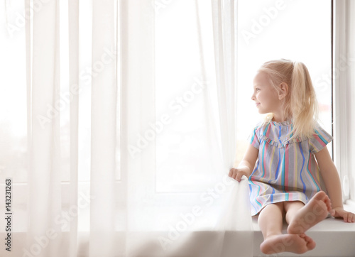 Cute little girl sitting on...