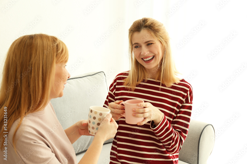 Happy young woman and her mother drinking tea at home Happy young woman and her mother drinking tea at home