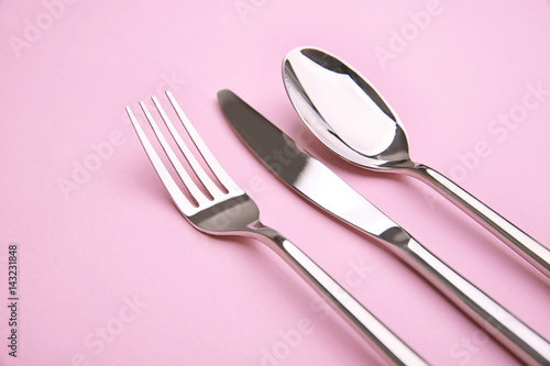 Cutlery set on color background