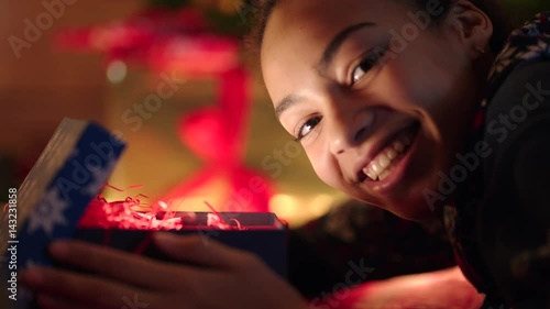 Wallpaper Mural Portrait of teen girl is openning gift and her face is shining with light Torontodigital.ca