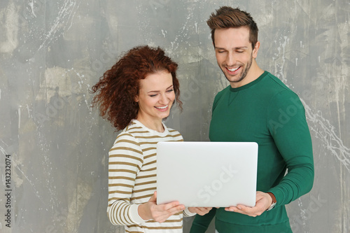 Happy young couple with lap...