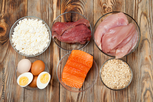Protein diet, fish, cheese, eggs, meat and chicken wooden background