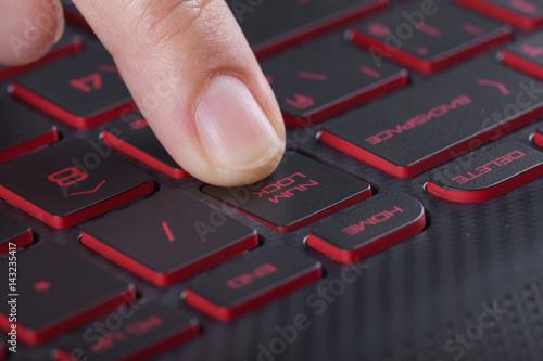 finger pushing num lock button on laptop keyboard photo