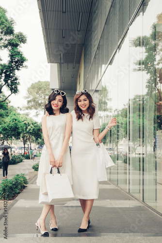 Beautiful asian girls with shopping bags walking on street at the mall © makistock