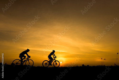 Silhouette of cycling on sunset background