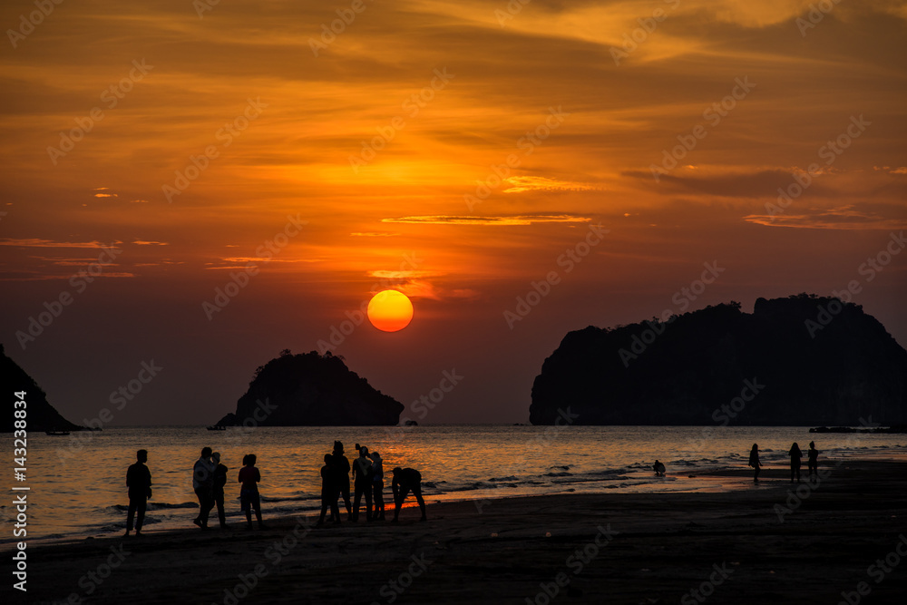 Several Silhouette people on beach have their own activities