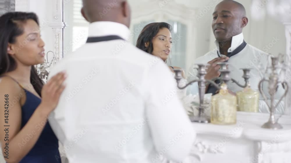 Affectionate couple in apartment getting ready to go out Affectionate couple in apartment getting ready to go out