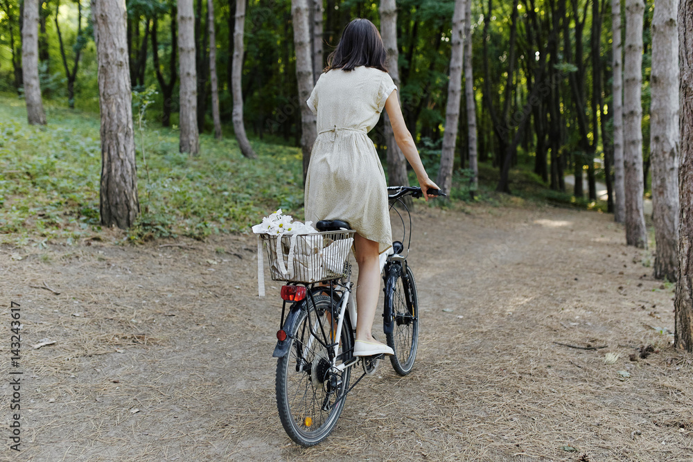 Fototapeta premium Young woman against nature background with bike