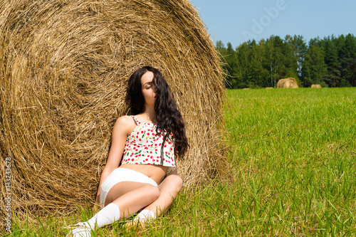 Valokuvatapetti beautiful brunette sleeping on haystack in summer