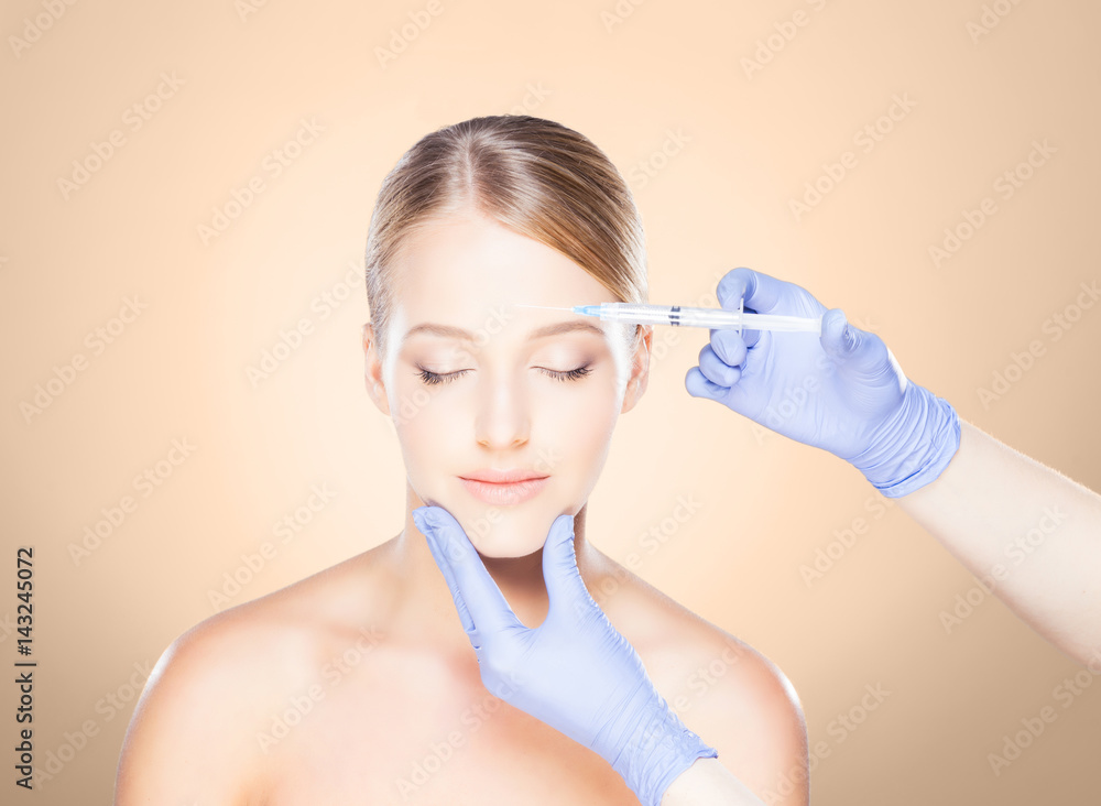 Doctor injecting in a beautiful face of a young woman. Plastic surgery concept. Doctor injecting in a beautiful face of a young woman. Plastic surgery concept.
