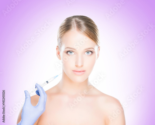 Young, beautiful and healthy woman having skin injections over magenta background. Plastic surgery concept.