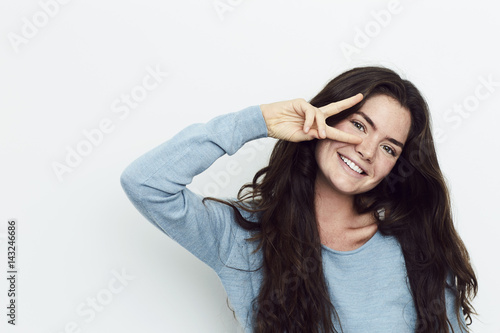 Beautiful woman with peace sign, smiling