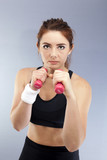 Sport serios  girl with red dumbbells boxer pose looks direct. Portrait