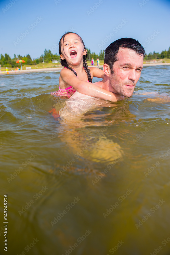 Mixed race father and daughter at the beach