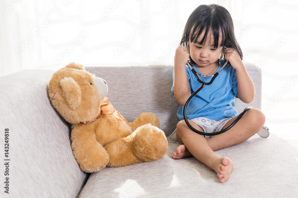 Asian Chinese little girl examination teddy bear with stethoscope Asian Chinese little girl examination teddy bear with stethoscope