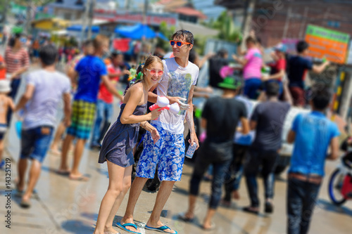 Thais and tourists shooting water guns, pour water on each other, having fun at Songkran festival, the traditional Thai New Year