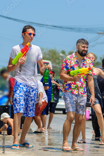 Thais and tourists shooting water guns, pour water on each other, having fun at Songkran festival, the traditional Thai New Year
