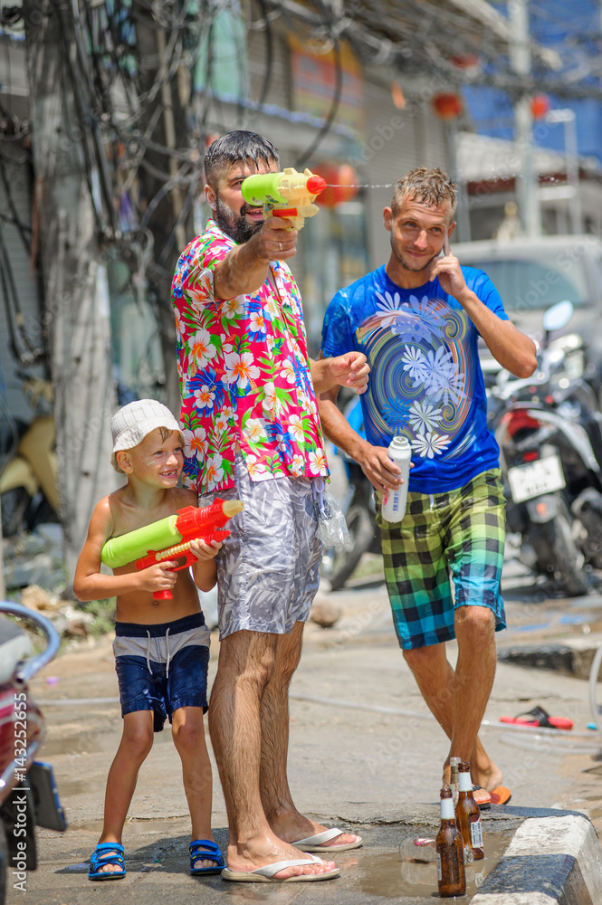 Obraz premium Thais and tourists shooting water guns, pour water on each other, having fun at Songkran festival, the traditional Thai New Year