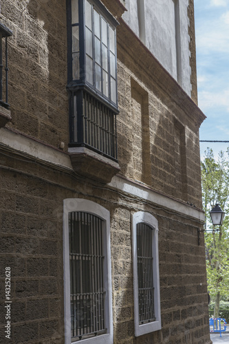 Detail of balconies and large windows on the time of the nineteenth century, Narrow street with traditional architecture in Cadiz, Andalusia, southern Spain