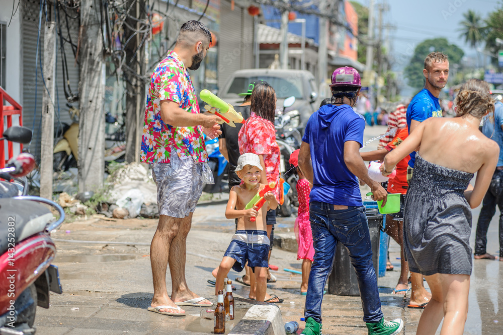 Obraz premium Thais and tourists shooting water guns, pour water on each other, having fun at Songkran festival, the traditional Thai New Year