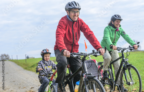 fröhliche Familie beim Radfahren an einem kühlen Herbsttag