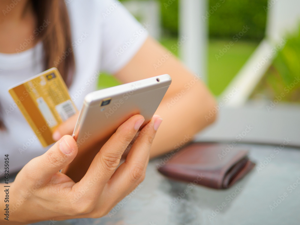 Online payment, women's hands holding a credit card and using smart phone for online shopping