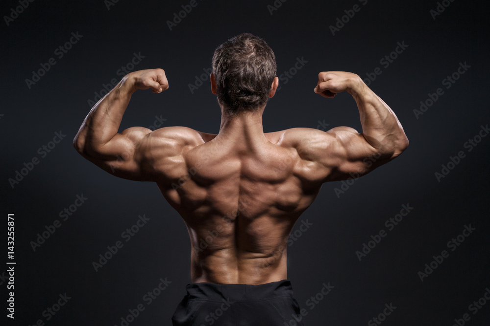 Handsome power bodybuilder showing his back