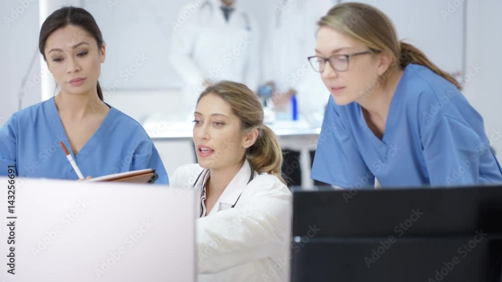 Team discussion in modern hospital, looking at computer & patient x-rays Team discussion in modern hospital, looking at computer & patient x-rays