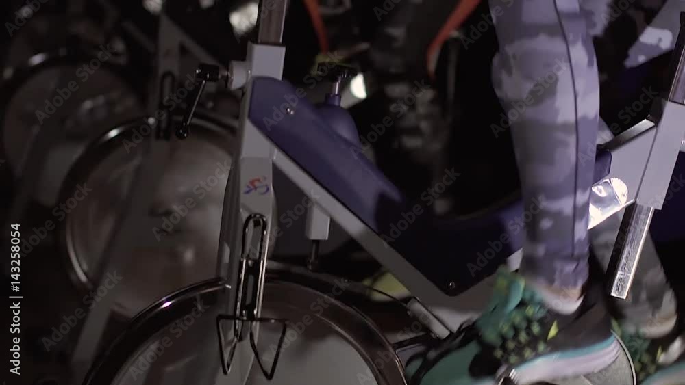 Close-up of active people using exercise bike to train Close-up of active people using exercise bike to train