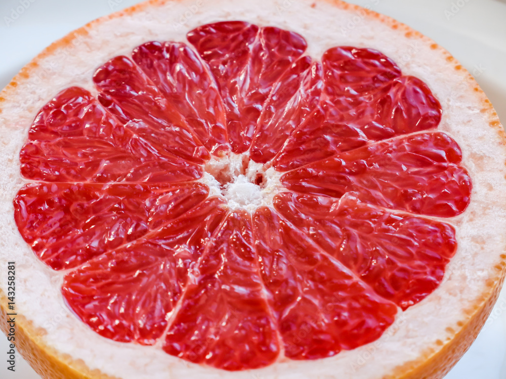 Half of a pink grapefruit on the plate. Half of a pink grapefruit on the plate.