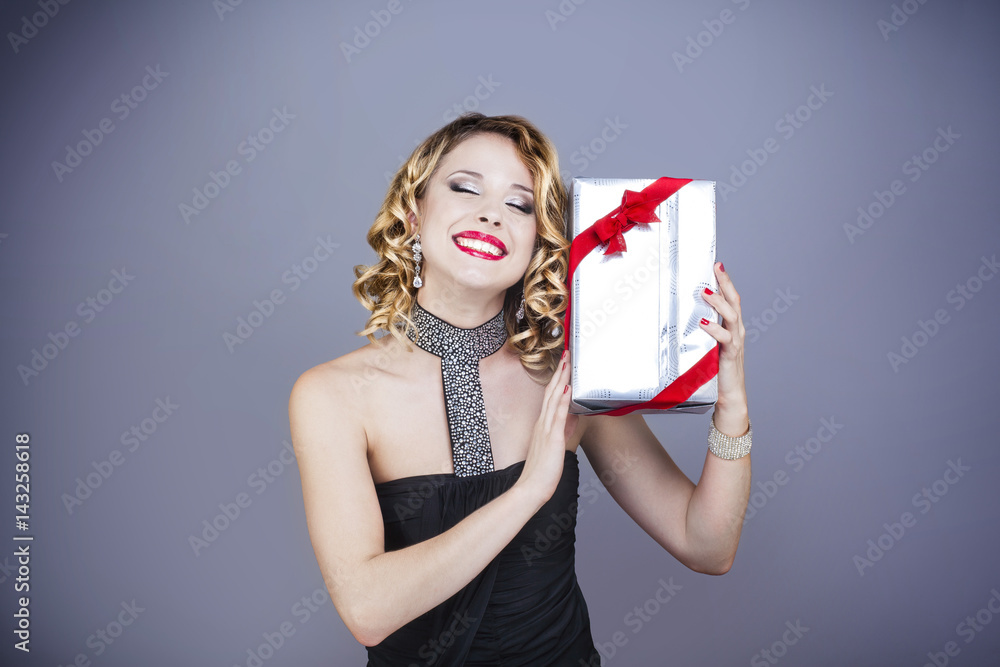 Portrait d'une jeune femme souriante, de face, un cadeau dans les mains Portrait d'une jeune femme souriante, de face, un cadeau dans les mains