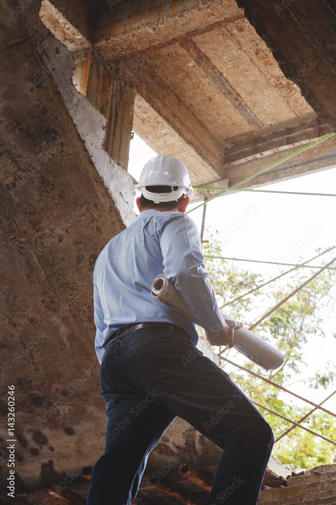 Fototapeta premium Engineer with blueprint in building construction site