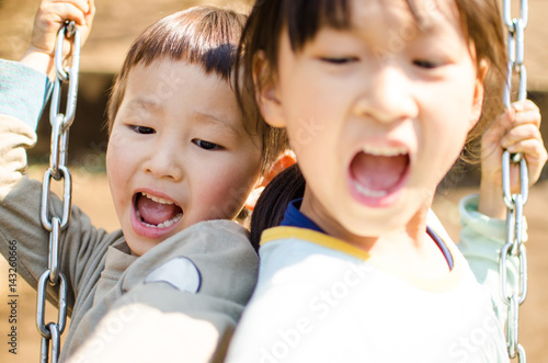ブランコで遊ぶ少年と少女 A boy and a girl playing with swings