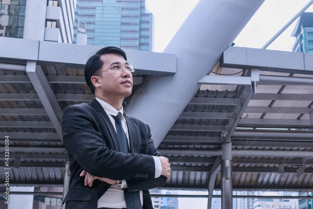 Confident Asian Businessman standing and looking at city for vision concept