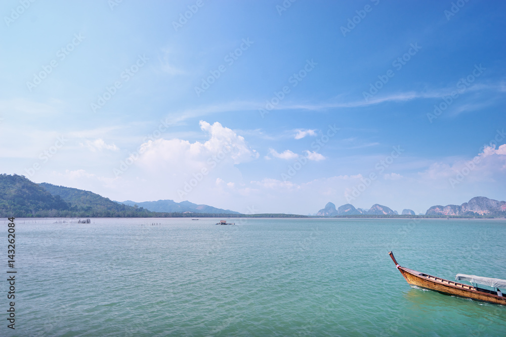 Beautiful seascape with traditional thai longtail boat and rocks on horizon. Beautiful seascape with traditional thai longtail boat and rocks on horizon.