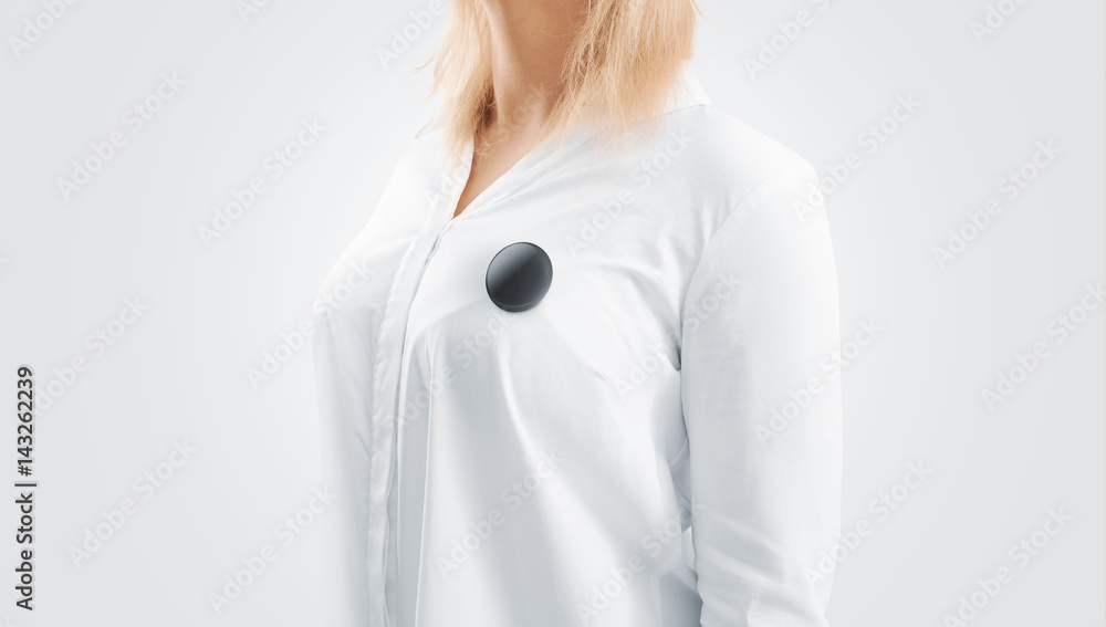 Blank black button badge mockup pinned on the womans chest, side view. Girl  wear white shirt