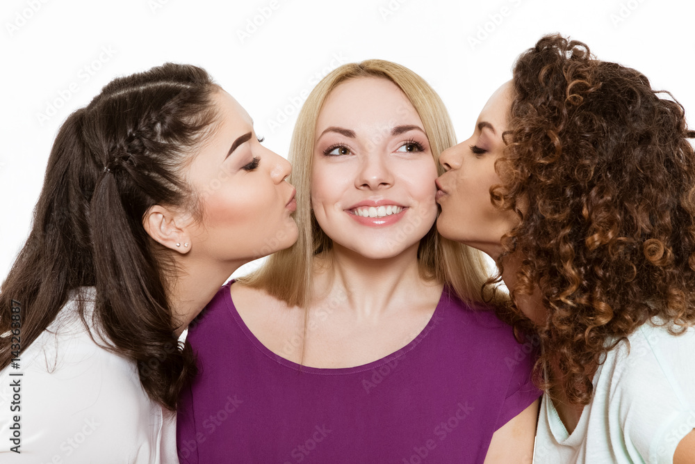 Two girls kissing their best friend on her cheeks Stock Photo Adobe Stock