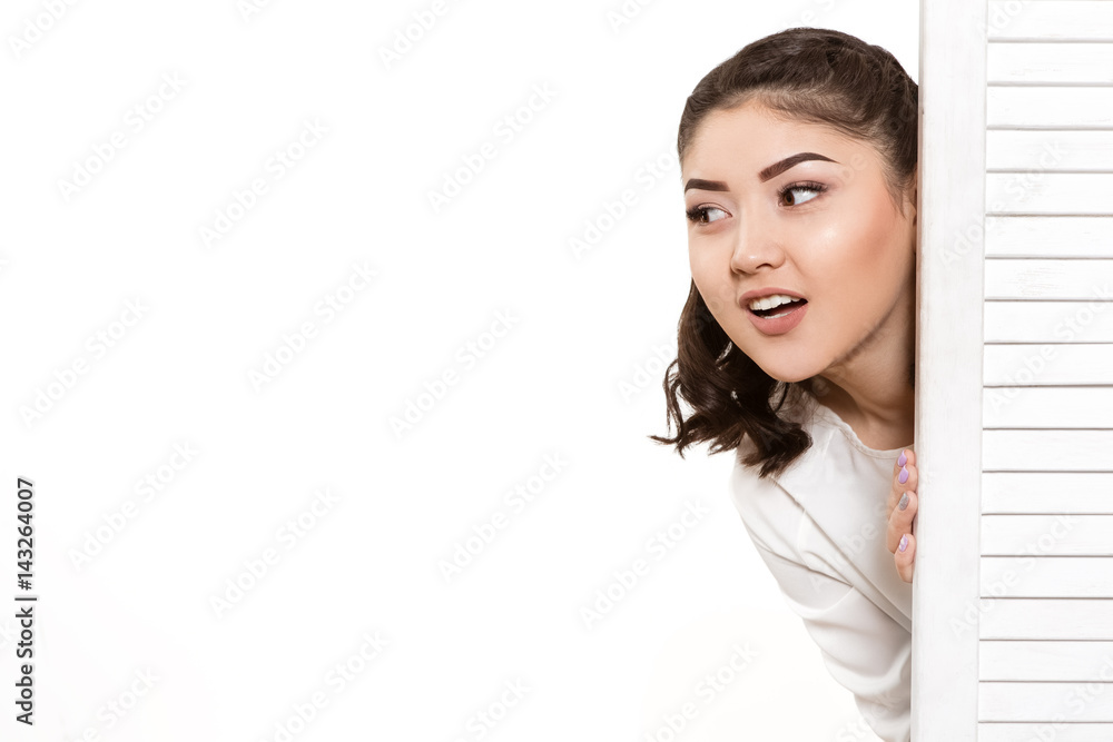 Beautiful woman looking out from behind the door Beautiful woman looking out from behind the door