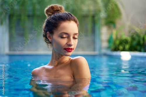Retreat and vacation.. Beautiful young woman relaxing in spa swimming pool. © luengo_ua